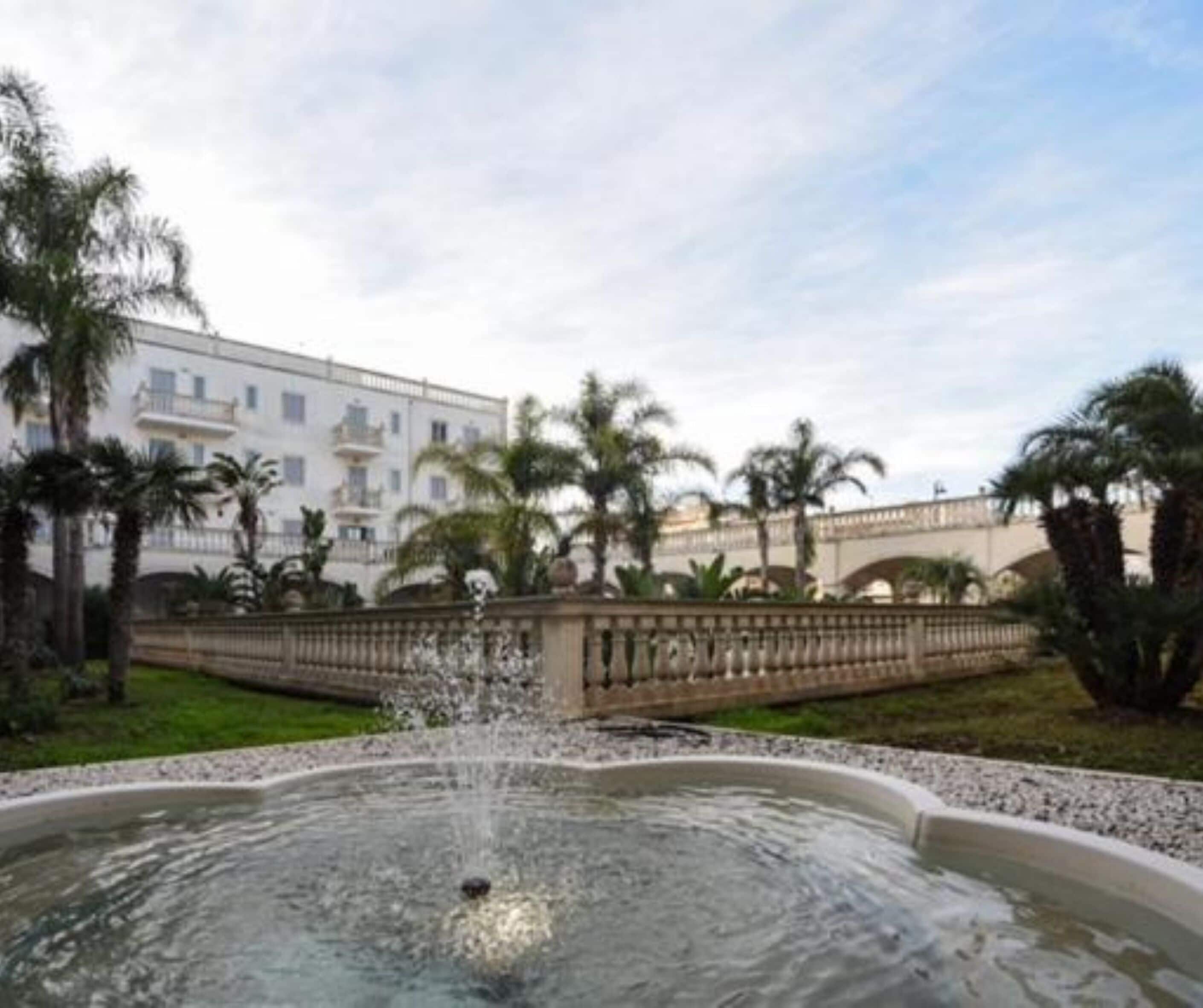 Una fuente en un patio con un edificio al fondo.