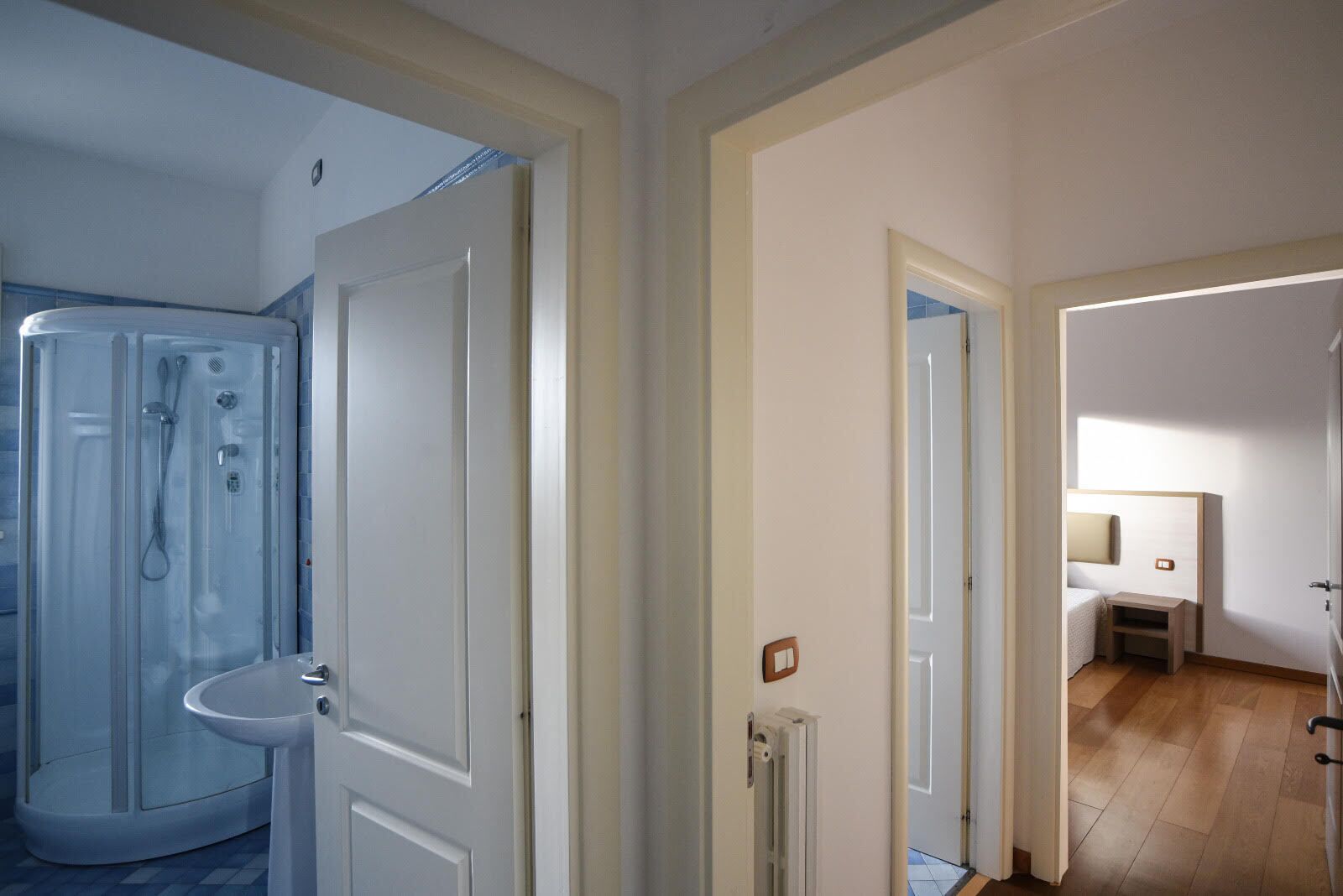 Habitación de hotel con ducha, inodoro y cama.