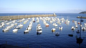 A marina with numerous boats docked, a lighthouse in the background, and a coastal landscape. - Seaside house in large enclosed garden in Binic (Binic-Étables-sur-Mer)