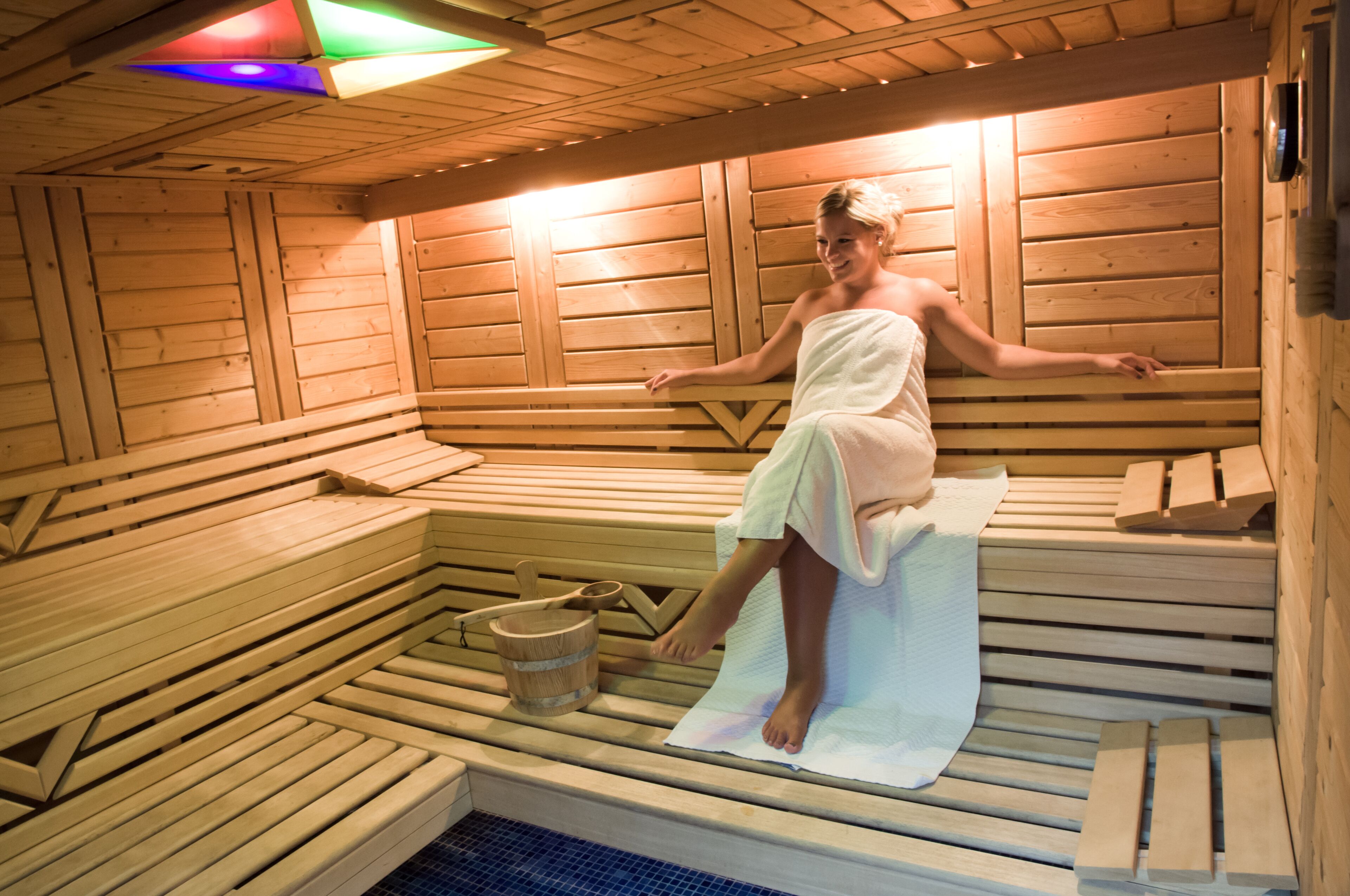 A sauna with wooden benches and a bench with a towel.