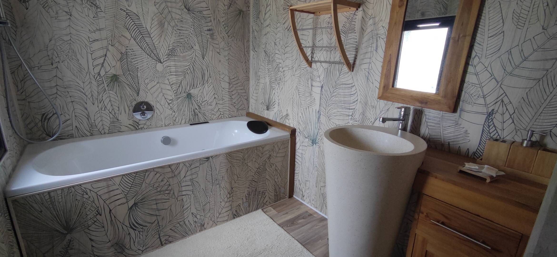 A bathroom with a bathtub, a sink, and a wooden vanity.