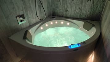 Una vasca idromassaggio con pannello di controllo digitale, circondata da pareti in legno.