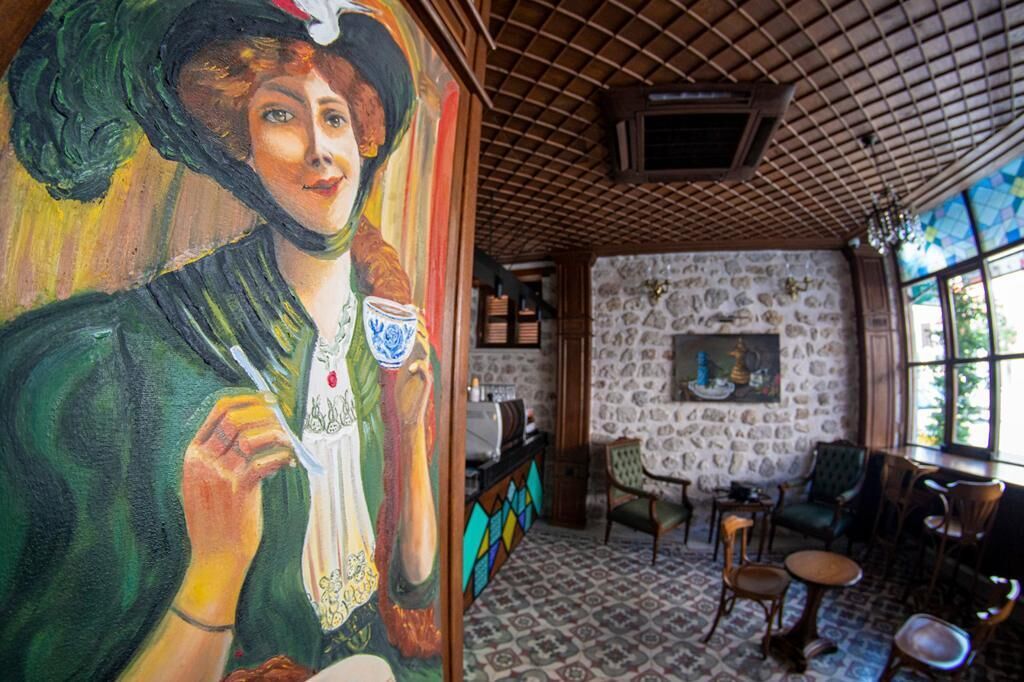 A room with a mural, stone walls, and a tiled floor.