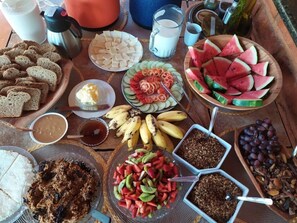 Un bufé de desayuno con diversas opciones de comida, como pan, queso, frutas y rellenos.