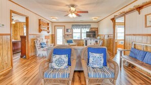 A cozy room with wicker furniture, a ceiling fan, and wooden floors. - Inlet Joy 2nd Row Channel Front (Garden City Beach)