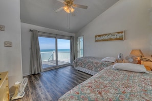 A bedroom with two beds, a ceiling fan, and a view of the ocean through a sliding glass door. - Sun Dial 33 -Three Bedroom, Two Bath Oceanfront Condo in Garden City Beach (Garden City Beach)