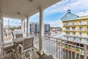 Enjoy the view from this hotel balcony with a table and chairs, overlooking the surrounding area.