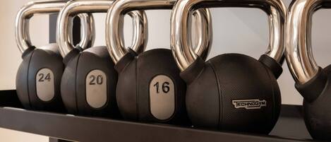 Un set di kettlebell con pesi da 16, 20 e 24 chilogrammi, disposti su un supporto.