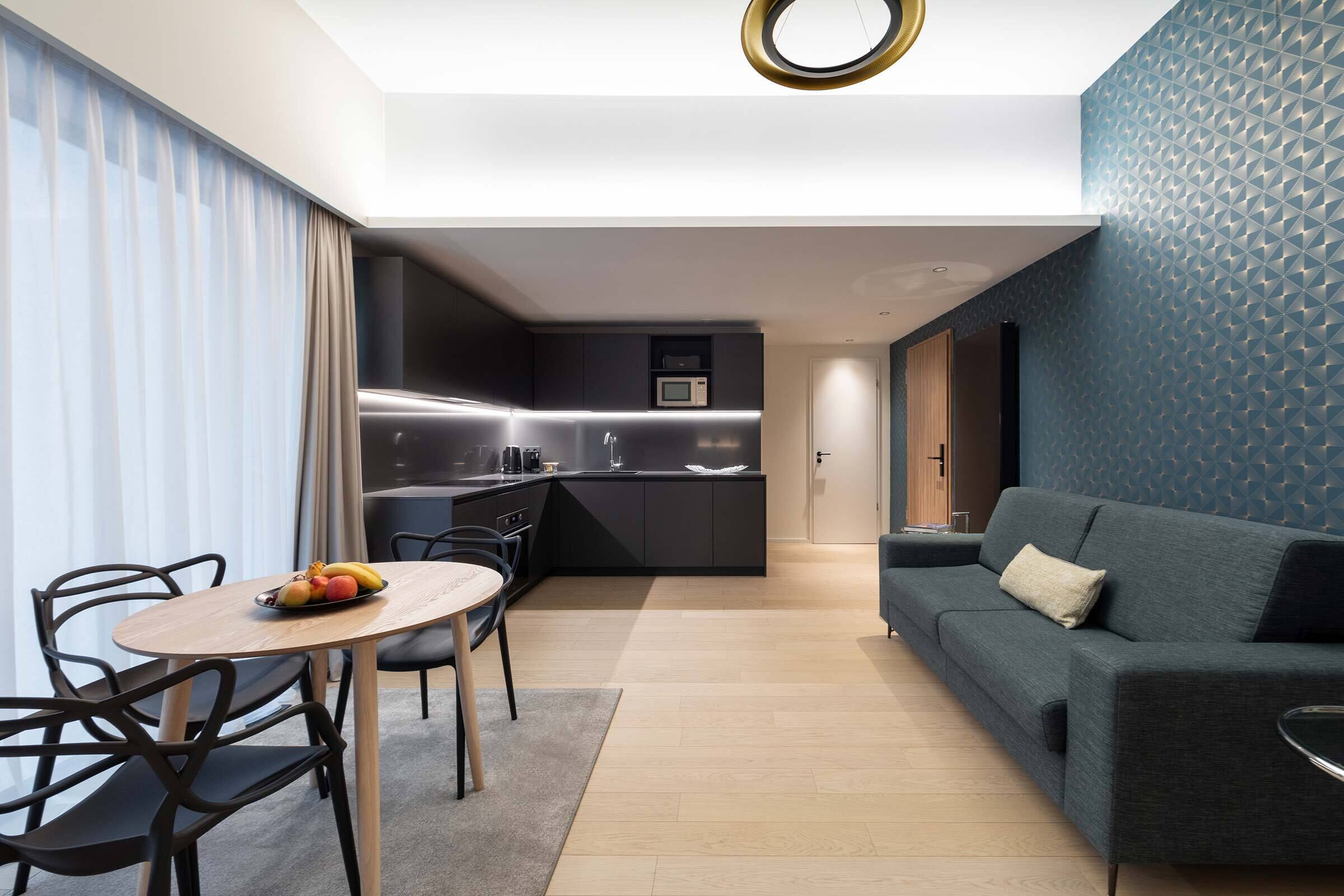 Un salon moderne avec un canapé et un coin repas comprenant une table et des chaises.