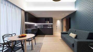 Un salon moderne avec un canapé et un coin repas comprenant une table et des chaises.