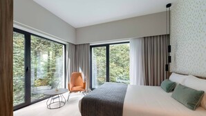 Un dormitorio moderno con una cama grande, una mesa redonda y una silla.
