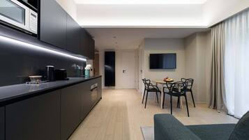 A modern kitchen with a built-in microwave and a dining area with a table and chairs.