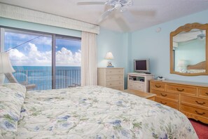 A bedroom with a bed, a dresser, a TV, a mirror, and a view of the ocean. - Keys Please is a 2bed/2bath condo located in desirable Key Colony Beach. (Key Colony Beach)