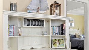 A white wooden desk with a chair, a bookshelf, and a small sailboat model. - Adagio - side unit in ofront bldg, 3br/3bath indoor pool (Ocean City)