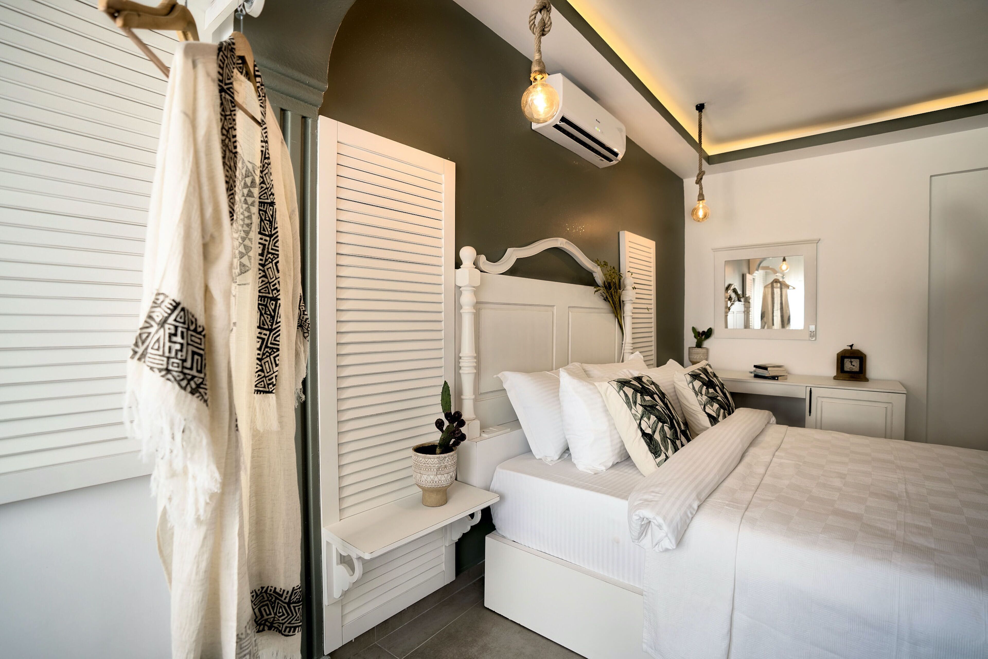 Un dormitorio con cama, mesita de noche y espejo.