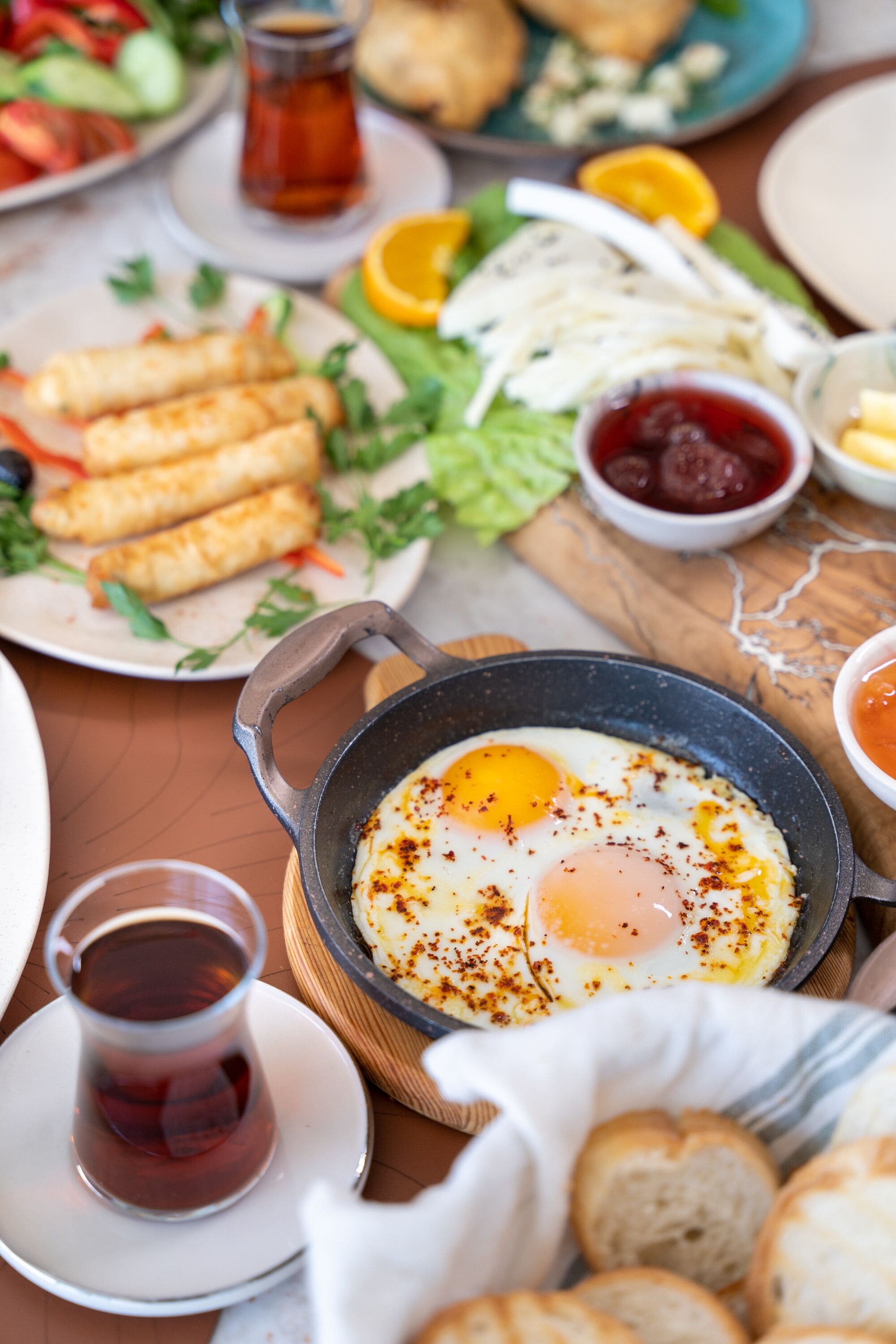 A breakfast setting with a skillet of eggs, toast, and various side dishes.