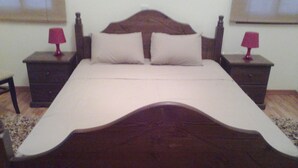 A bed with a wooden headboard, two bedside tables with lamps, and a plain wall. - Romantic 5 Bedroom Villa with private salted Pool. Cyprus (Fyti)