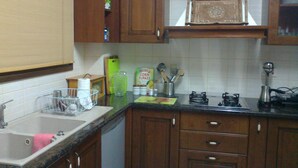 A kitchen with wooden cabinets, a sink, and various kitchen items like a kettle, a cutting board, and a box of corn flakes. - Romantic 5 Bedroom Villa with private salted Pool. Cyprus (Fyti)
