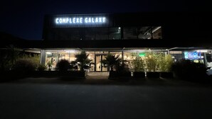 Ein Gebäude mit einer Beschilderung, auf der „COMPLEX GALAXY“ steht, bei Nacht.