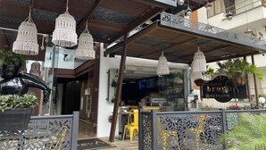 A hotel entrance with a modern design, featuring intricate metal railings, hanging macrame chandeliers, and a visible reception area. - Trugo Luxury Rooms (Armenia)