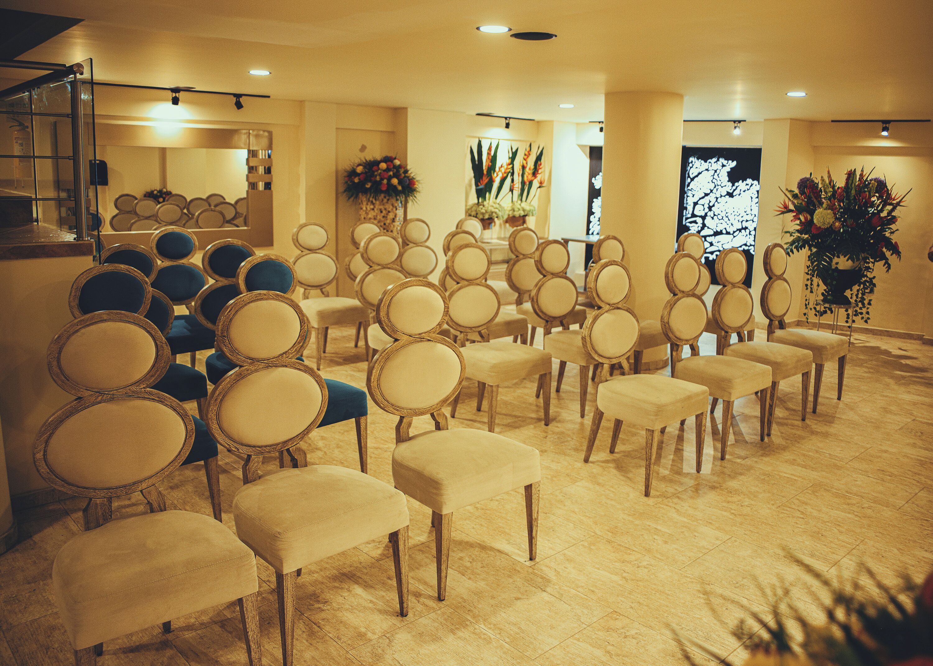 A conference room with rows of chairs, a podium, and floral decorations.