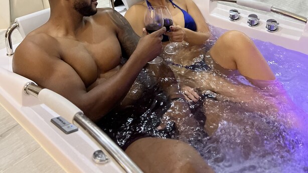 A couple in a hot tub with a marble wall and potted plants in the background. - Trugo Luxury Rooms (Armenia)