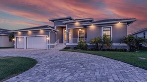 A modern two-story house with a driveway, garage, and well-maintained lawn.