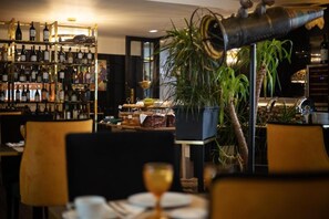 A restaurant interior with a wine rack, a potted plant, and a dining table with chairs. - Hotel República (Tomar)