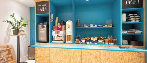 Una barra de café con una máquina de café, un tostador y diferentes alimentos.