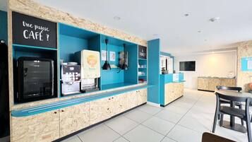 Un café moderno con mostrador de madera, máquinas de café y un cartel que dice "Une pause CAFE ?".