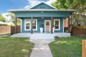 A single-story house with a porch, a front door, and a mailbox.