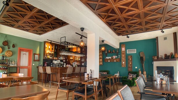 Un restaurante acogedor con mobiliario de madera, una zona de bar y una chimenea.