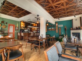 Un restaurante acogedor con mobiliario de madera, una zona de bar y una chimenea.