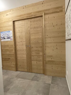 En garderob i trä med två dörrar och en affisch på väggen.