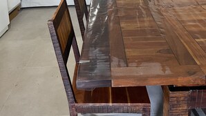 Un coin repas avec une table et des chaises en bois, un canapé, une télévision et une lampe.