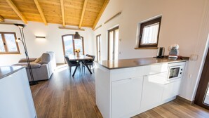 A modern kitchen with white cabinetry, a built-in oven, and a coffee maker on the counter. - DALT'S COUNTRY (Sant Joan de les Abadesses)