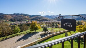 A scenic view of a town with a sign reading "MASIA DE DALT" and a clear sky. - DALT'S COUNTRY (Sant Joan de les Abadesses)