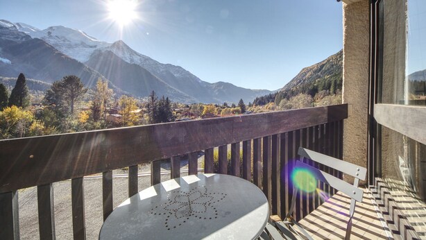 A balcony with a view of snow-capped mountains and a clear sky.