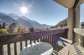 Uma varanda com vista para montanhas cobertas de neve e um céu limpo.
