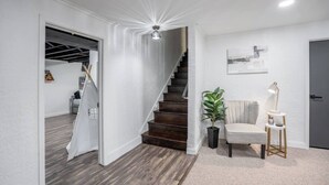 Et moderne interiør med trappe, siddepladser med lampe og en plante.