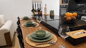 A dining table set with green plates and bowls, a wine glass, and a basket of oranges. - Captivating 2-bed Apartment in Tunis (Tunis)