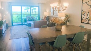 A dining area with a wooden table, teal chairs, and a chandelier. - South Seas Beach Villa 2414 (Captiva)