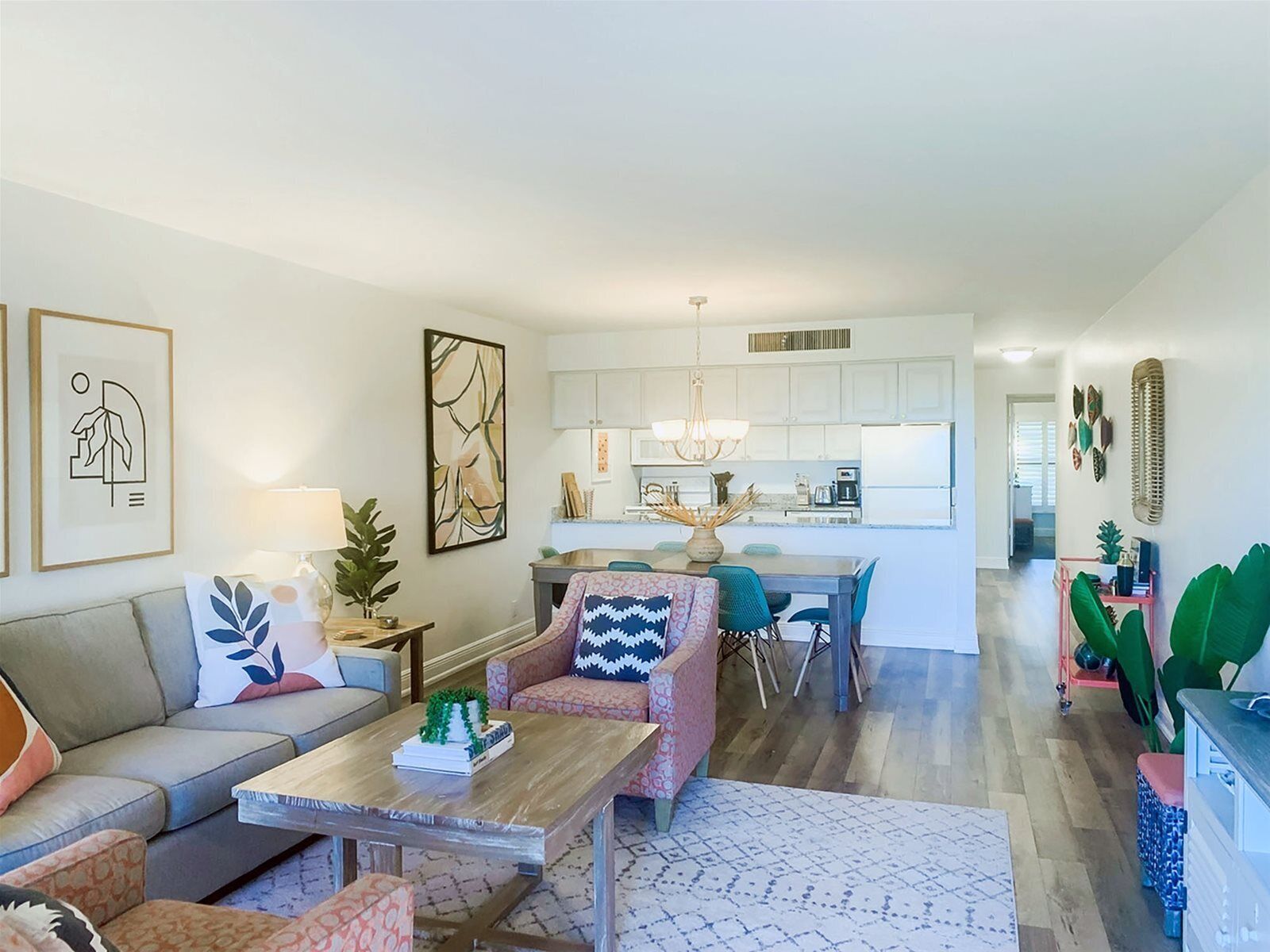 Una sala de estar moderna con sofá, mesa de centro y comedor con sillas y mesa.