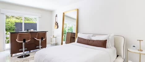 Un dormitorio moderno con una cama grande, un escritorio y un espejo.