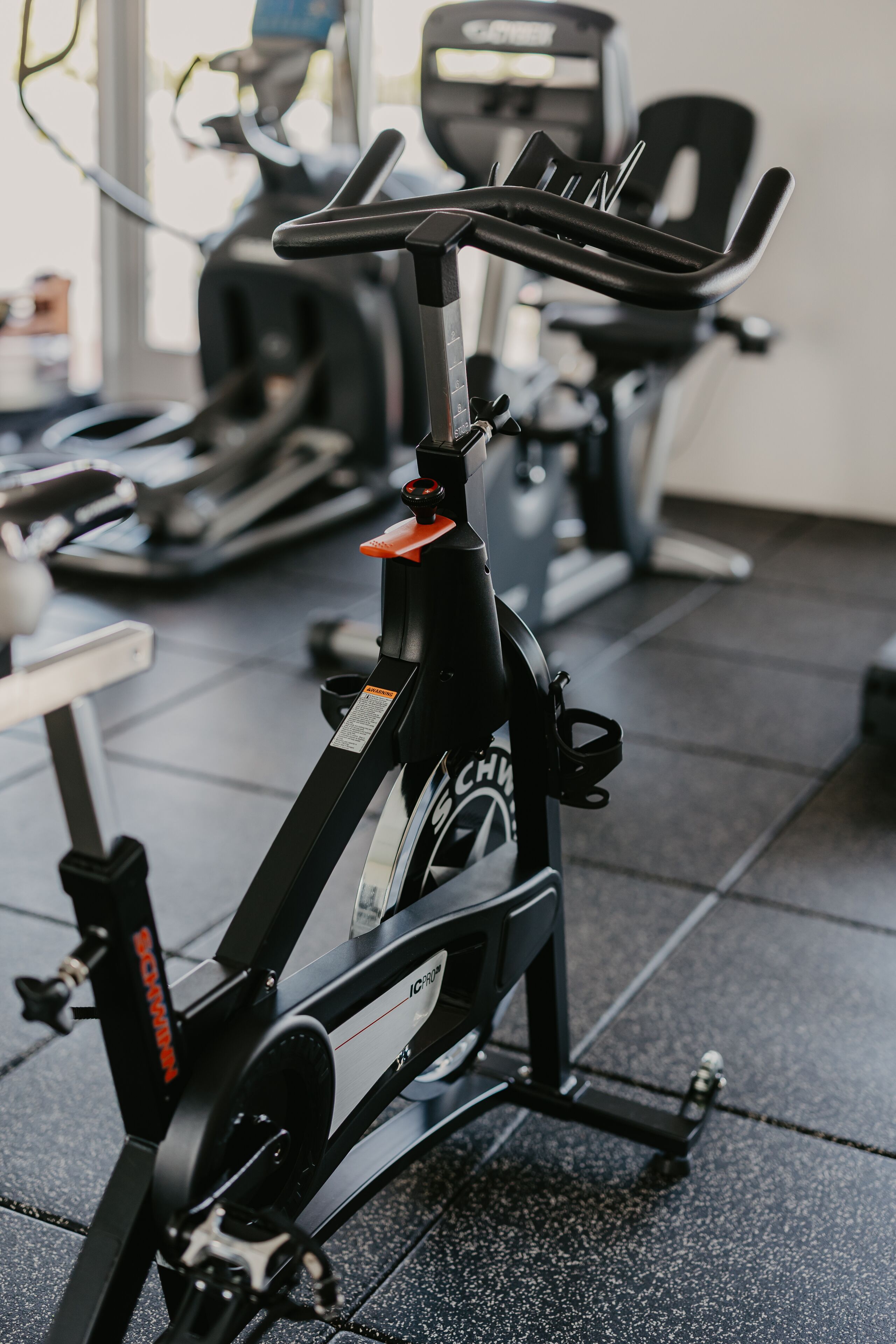 A stationary bike in a gym with a control panel and a display.