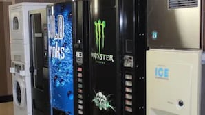 Vending machines, a washer, and an ice dispenser in a commercial setting. - Garden City Inn (Garden City)