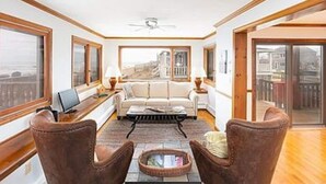 A spacious living room with a sofa, two armchairs, a coffee table, and a view through large windows. - Scituate-Weddings, Family Gatherings, Pet Friendly (Scituate)