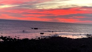 A beach with a rocky shoreline and a sunset sky. - Scituate-Weddings, Family Gatherings, Pet Friendly (Scituate)