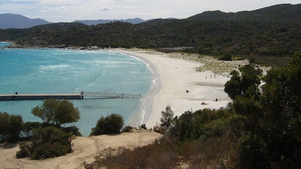 A beach with clear turquoise waters, a sandy shore, and a pier extending into the sea. - 2-standing seaside villa, breathtaking view of the Gulf of Saint Florent (Saint-Florent)