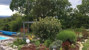 A landscaped garden with a variety of plants and a small pond. - Barjac Villa Pastis - Self-catering cottage with swimming pool and view of the Cevennes mountains (Barjac)
